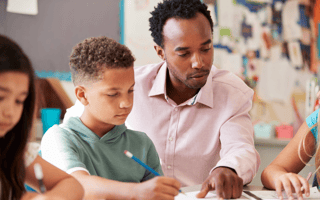 teacher with student in classroom