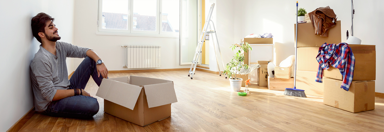 man sitting in new apartment with boxes